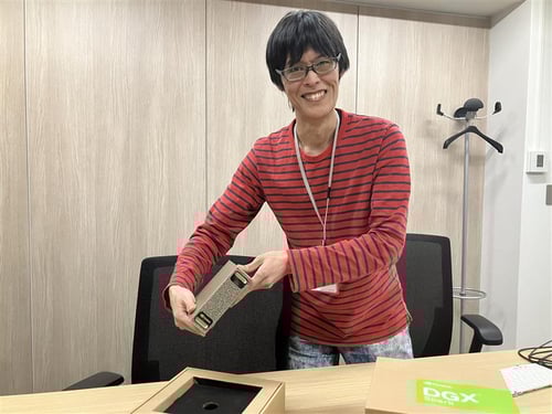 NVIDIA DGX Sparkの本体を手にする当社エンジニアA氏